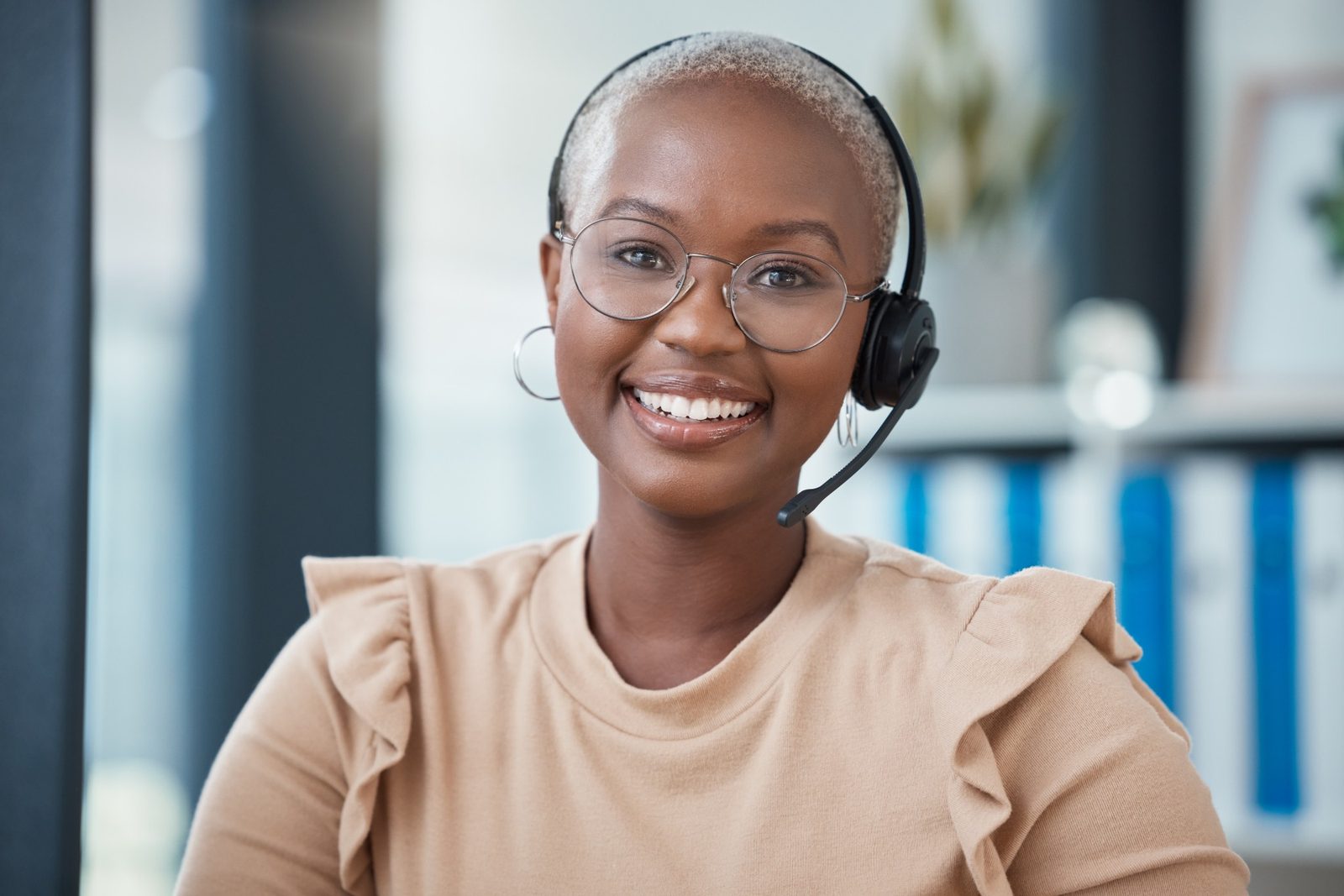 A smiling Tradecall Pro sales associate wearing a headset at her desk