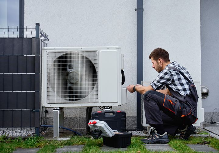 HVAC technician servicing an outdoor heat pump