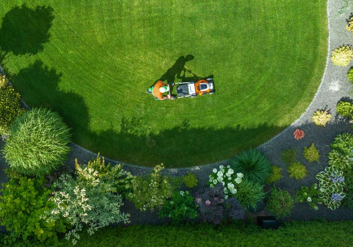 Aerial view of a landscaper mowing a lawn